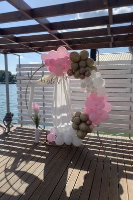 Dekoracija za devojačko veče sa polulukom balona u roze, sivim i belim nijansama sa dodatnim ukrasima.