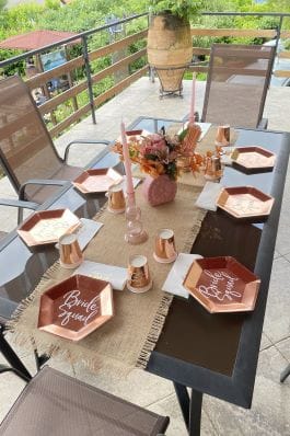 Dekoracija stola za devojačko veče sa tanjirima i čašama u bakarnim nijansama.